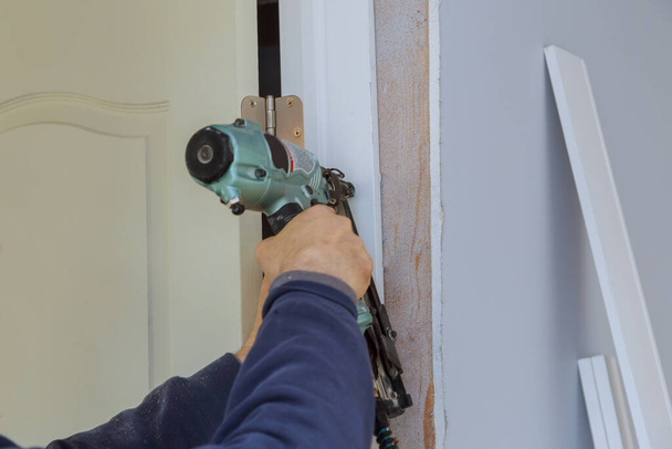 Výstavba dřevěného rámu montáž interiérových dveří v pracovníka pomocí hřebíkové pistole - Fotografie, Obrázek