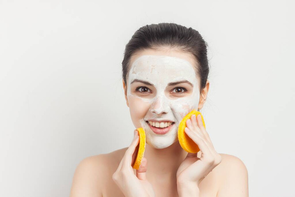 Χαρούμενη μελαχρινή σκουπίζει τη μάσκα της με σφουγγάρι scrub skincare - Φωτογραφία, εικόνα