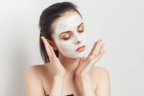 parmantig brunette met gezichtsmasker verjonging spa behandelingen - Foto, afbeelding