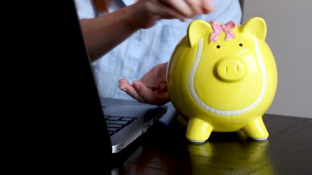 Nainen liike-elämässä laittaa kolikon possupankkiin, säästöt tulevaisuutta varten, pankkitalletus - Materiaali, video