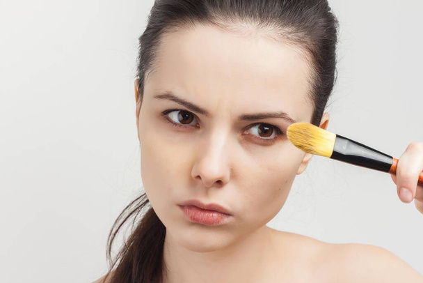 femme épaules nues brossage crème sur le visage vue recadrée - Photo, image