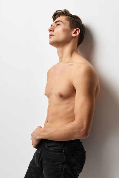 Young man with a naked torso looking up posing self-confidence light background - Photo, Image
