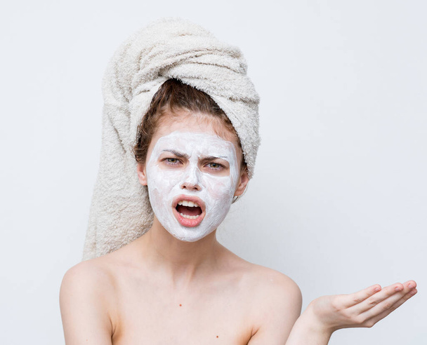 mujer bonita con una toalla en la cabeza máscara cara hombros desnudos aspecto atractivo - Foto, Imagen