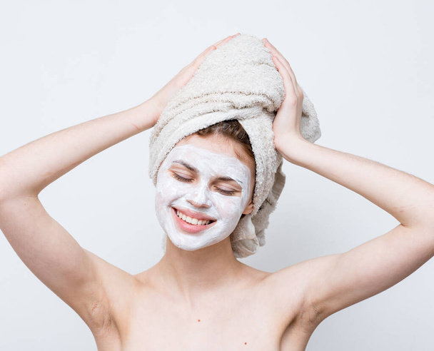 mulher bonita com ombros nus rosto toalha de creme na cabeça pele limpa - Foto, Imagem