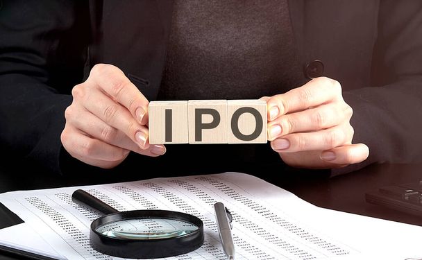 podnikatelka držící dřevěný blok s textem IPO Úvodní veřejná nabídka, obchod - Fotografie, Obrázek
