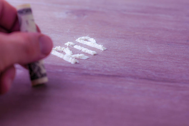 abreviatura "resto en paz" hecha de tiras de cocaína en una mesa de madera, enfoque corto, tonificación - Foto, Imagen
