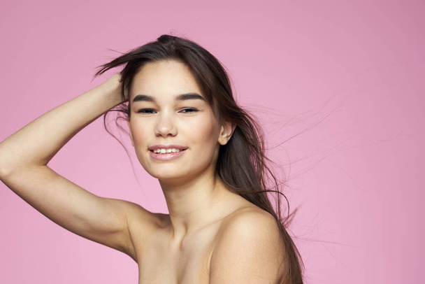 Frau mit nackten Schultern Haarpflege Make-up saubere Haut rosa Hintergrund - Foto, Bild