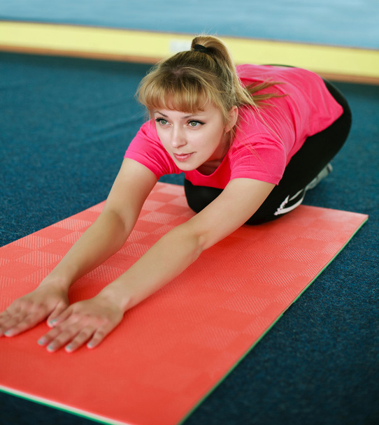  jonge vrouw doen stretching oefening in de sportschool centrum - Foto, afbeelding