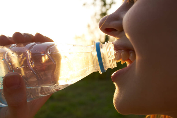 nő iszik vizet egy műanyag palack szabadban nyáron - Fotó, kép