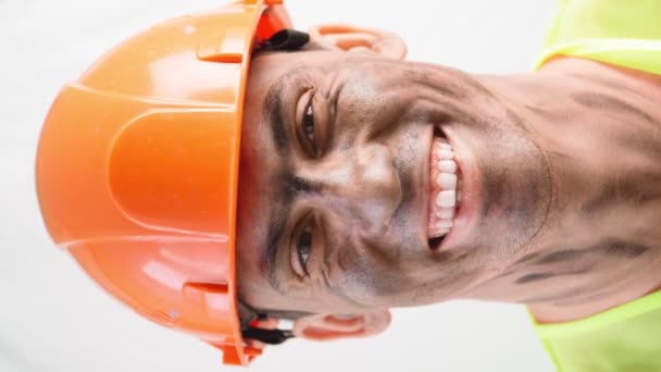 Portrét smíšené závod chlap s špinavou tváří v práci tvrdý klobouk úsměvy sněhobílý úsměv - Záběry, video