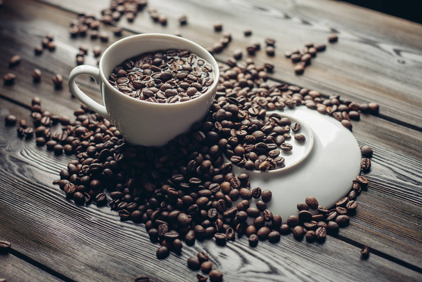 fehér csésze és csészealj kávébab egy fa háttér aroma ital - Fotó, kép