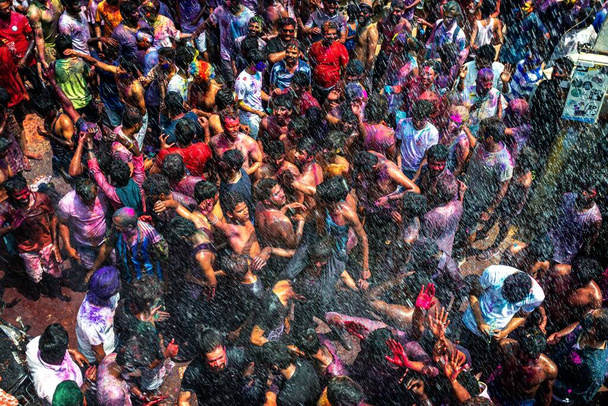 10.03.2020 Hampi. India. Crowd of people throw loose color paint at each other before the start of lockdown and covid 19 pandemic. Festival of love, triumph of good over evil and arrival of spring - Fotografie, Obrázek