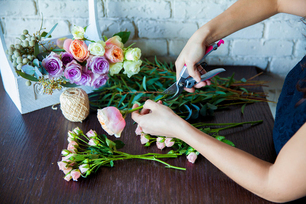 Florist at work. Woman making spring floral decorations - Фото, изображение