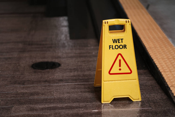 segno giallo di cautela riserva pulizia sul pavimento bagnato - Foto, immagini