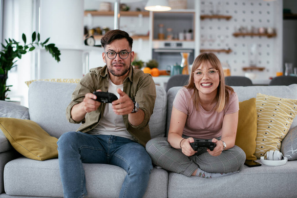 pareja jugando videojuego en el sofá en casa - Foto, Imagen