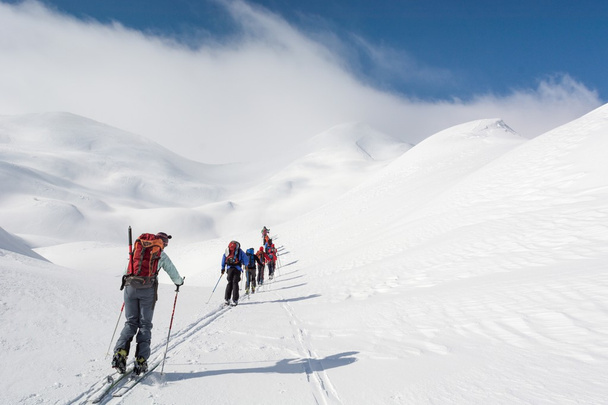 Skiers walking towards mountains - Фото, зображення