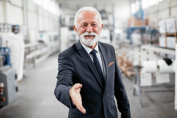 Portret przystojnego starszego biznesmena. Mężczyzna uścisk dłoni w fabryce. - Zdjęcie, obraz