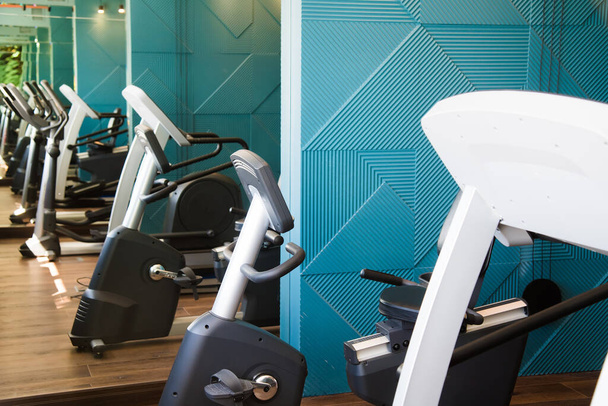 Intérieur moderne de la salle de gym avec équipement. Sonnettes, haltères, tapis roulants, équipement cardio - Photo, image