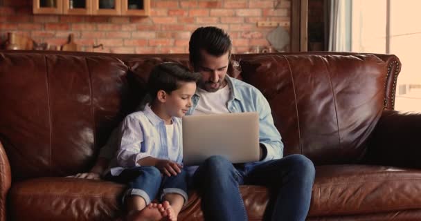 Little boy learning using computer applications with dad. - Metraje, vídeo