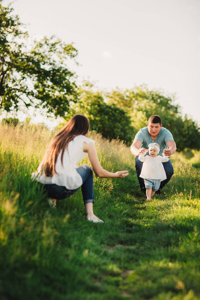 Rodina si užívá společný život v letním parku. Šťastná mladá rodina venku. Matko, otec objímá svou dceru venku a baví se v přírodě. Koncept rodinné letní dovolené. - Fotografie, Obrázek