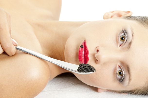 Porträt einer liegenden Frau mit schwarzem Kaviar - Foto, Bild