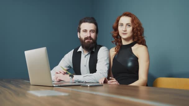 Man and woman working together in the office. Happy people smiling at work and at work in the office. Bearded man and woman with red hair of Caucasian nationality. - Footage, Video