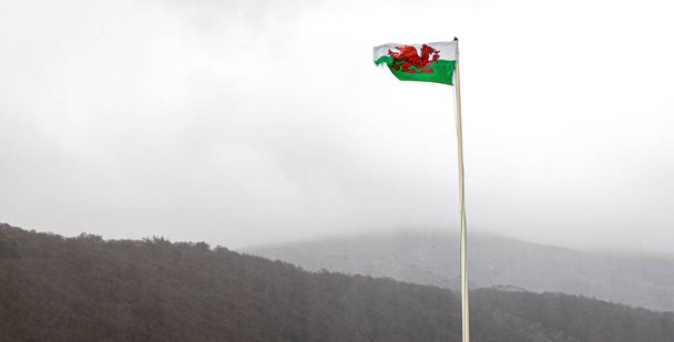 Welsh flag at the lake of Snowdonia at stormy weather, Wales, UK - Photo, Image