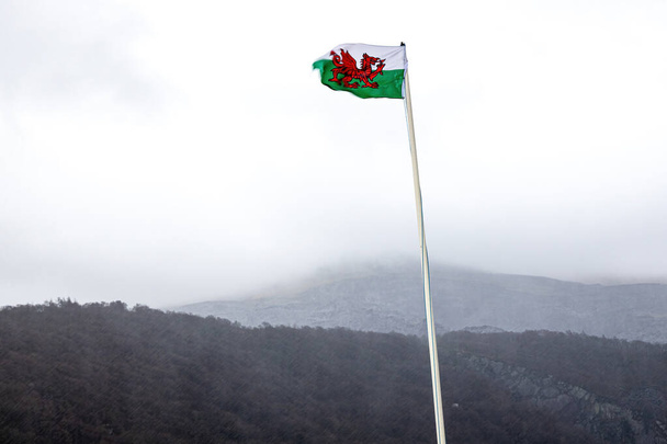Walijska flaga nad jeziorem Snowdonia przy burzliwej pogodzie, Walia, Wielka Brytania - Zdjęcie, obraz
