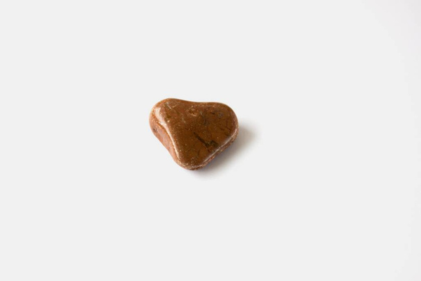 Brown stone in the shape of a heart on a white background. - Photo, Image