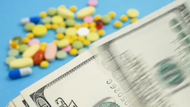 Diverse pillole colorate, tablet, capsule su sfondo denaro. Concetto di trattamento costoso, assicurazione medica. - Filmati, video