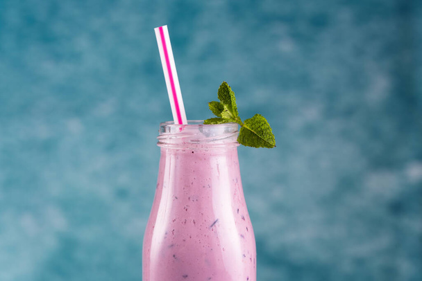 Blueberry smoothie with a straw and mint garnish - Photo, Image