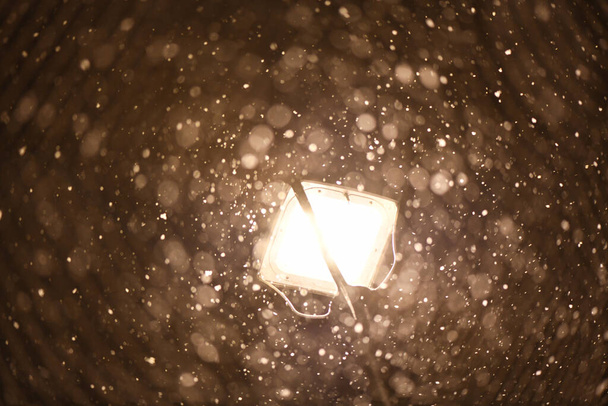 La linterna brilla en la calle, que está cubierta de nieve. En febrero, el tiempo en Europa se convirtió realmente invierno. - Foto, imagen