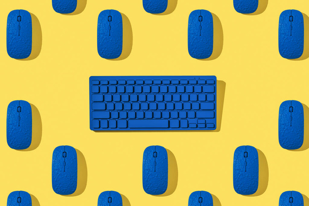 Ein Muster aus blauen Computermäusen und einer Tastatur auf gelbem Hintergrund. Computer-Zubehör. - Foto, Bild