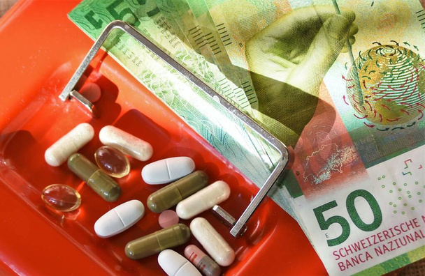 geneeskunde en Zwitserse geld op de rode kluis - Foto, afbeelding
