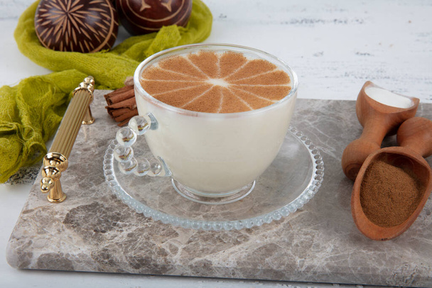 Чашка солоного гарячого напою в Туреччині з коринкою і здоровою спецією і осінню зиму на білому сільському старовинному дерев'яному столі.  - Фото, зображення