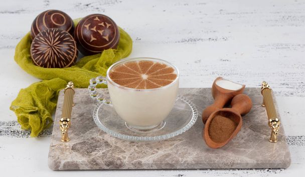 Чашка солоного гарячого напою в Туреччині з коринкою і здоровою спецією і осінню зиму на білому сільському старовинному дерев'яному столі.  - Фото, зображення