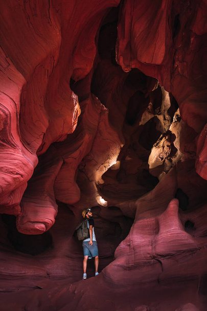 Turista dobrodruh stojící v zátokách De Can Riera jeskyně v Torrelles, Barcelona, Katalánsko, Španělsko. Úžasná pískovcová formace uvnitř jeskyně. Koncept cestování, objevování a objevování skrytých míst. - Fotografie, Obrázek