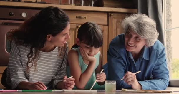 Τρεις γενιές γυναικών οικογένεια ξαπλωμένη στο πάτωμα σχέδιο με βούρτσες - Πλάνα, βίντεο