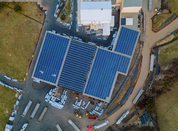 Paneles solares instalados en un techo de un gran edificio industrial un almacén. - Foto, imagen