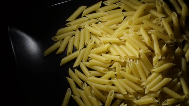Macaronis crus dans un plateau noir gyrating - Séquence, vidéo