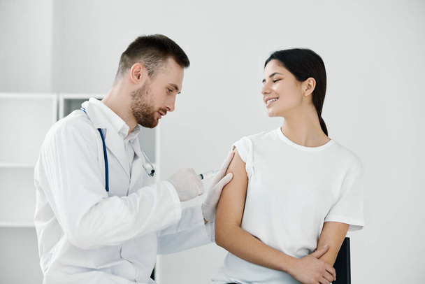 the doctor gives an injection of coronavirus infection into the patients shoulder vaccination - Zdjęcie, obraz