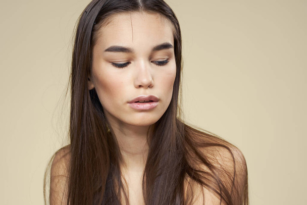 Красивая женщина голые плечи косметика чистый уход за кожей волос бежевый фон - Фото, изображение