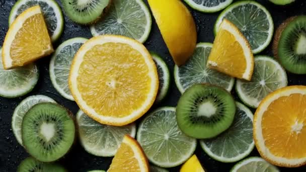 Variety of citrus fruits including lemons, limes, kiwi. Rotating top view - Footage, Video