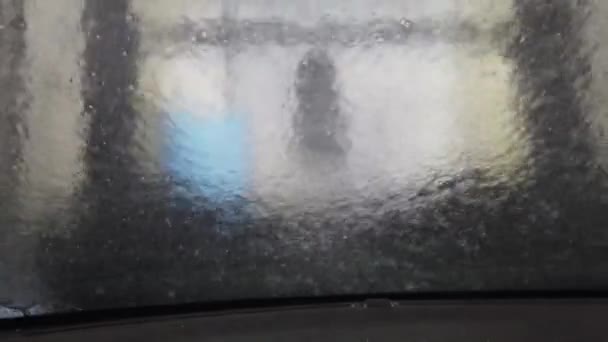 Τα πινέλα του πλυντηρίου αυτοκινήτων πλένουν το μπροστινό γυαλί με σαπούνι - Πλάνα, βίντεο