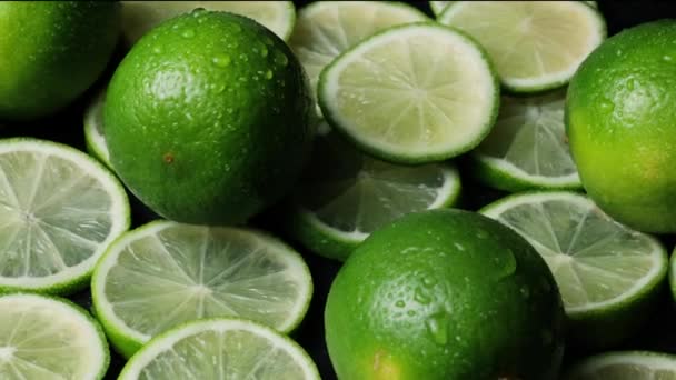 Lime szeletek közelkép, makroháttér, gyümölcsök felső nézet. Forgás. friss mész italgyártáshoz - Felvétel, videó