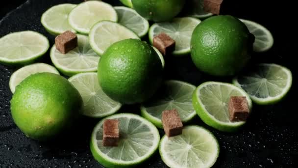 Lime slices closeup, macro background, fruits top view. Rotate. fresh lime with cane sugar lumps - Footage, Video