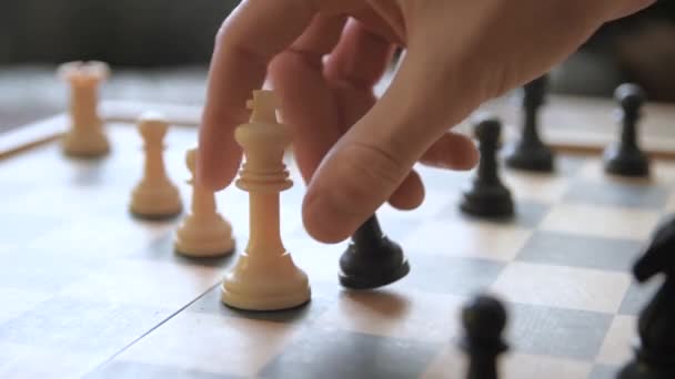 Um homem move peças de xadrez num tabuleiro de xadrez. Contra o pano de fundo de coisas antigas vintage. Jogo de xadrez. Jogador faz um movimento, desenvolvimento de estratégia de xadrez, jogo de tabuleiro com o adversário. - Filmagem, Vídeo