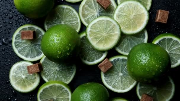 Lime slices closeup, macro background, fruits top view. Rotate. fresh lime with cane sugar lumps - Footage, Video