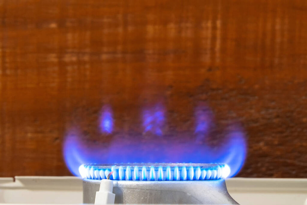 Llama azul de gas natural en cocina sobre fondo de madera - Foto, Imagen