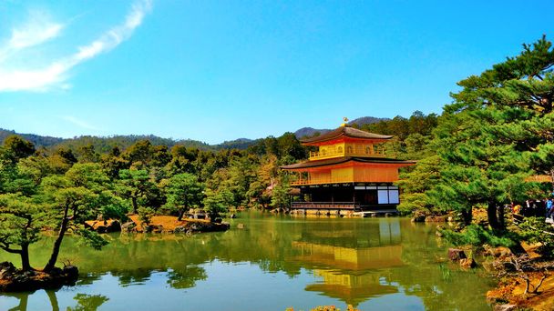 Pabellón de oro en la ciudad japonesa de Kyoto. El hermoso parque alrededor pertenece al complejo. Hace frío Tiempo soleado. - Foto, imagen